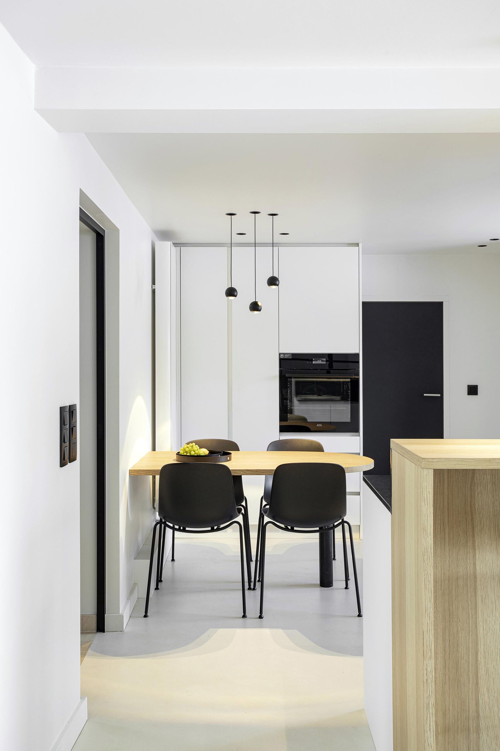 Cuisine contemporaine ouverte dans une maison ancienne rénovée, avec volumes décloisonnés, lumière naturelle et aménagement sur mesure dans une ambiance chaleureuse et haut de gamme