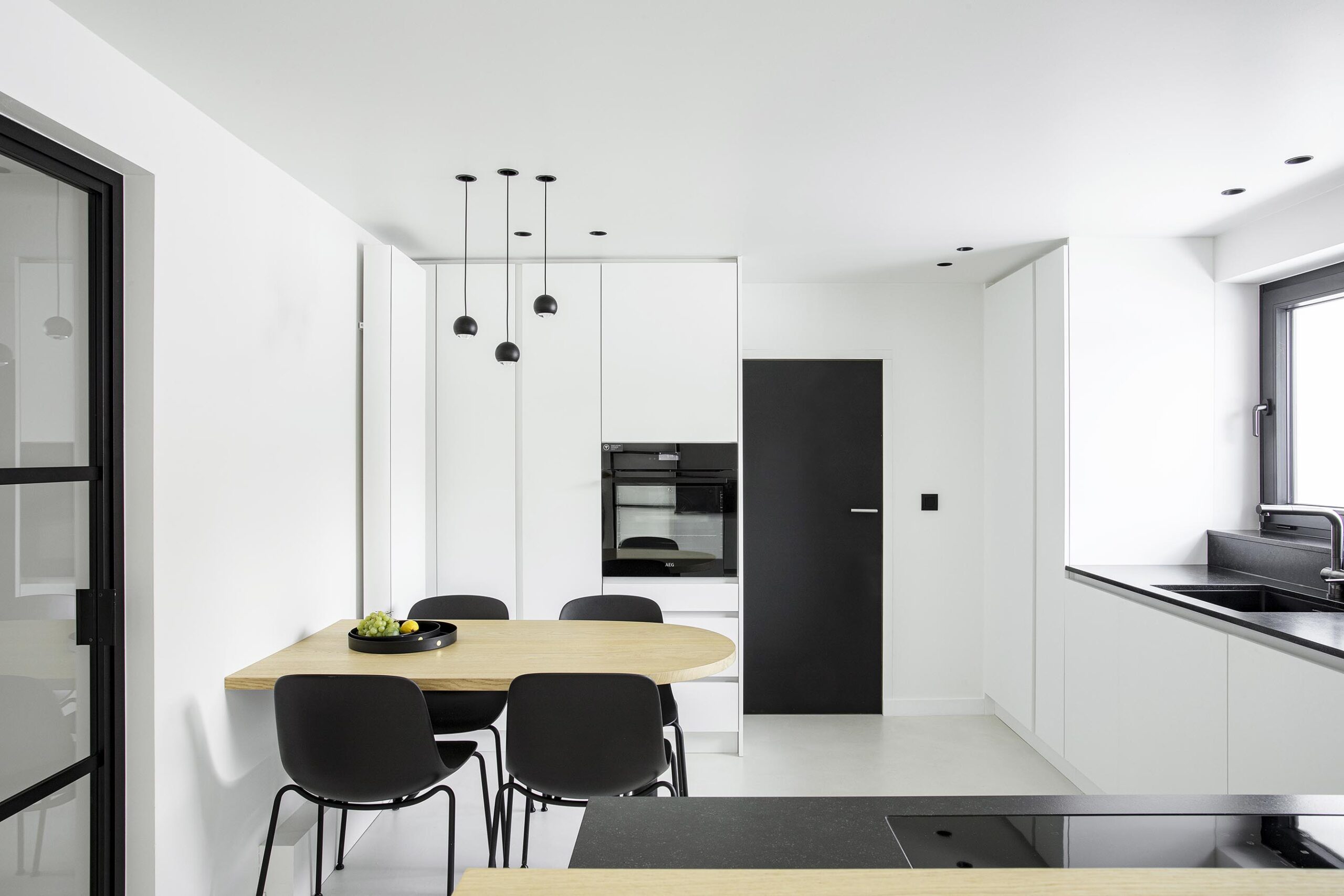 Cuisine contemporaine ouverte dans une maison ancienne rénovée, avec volumes décloisonnés, lumière naturelle et aménagement sur mesure dans une ambiance chaleureuse et haut de gamme
