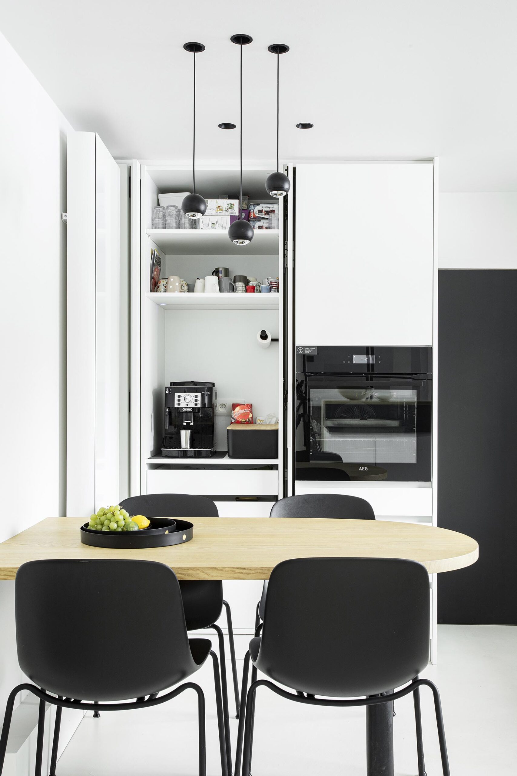 Cuisine contemporaine ouverte dans une maison ancienne rénovée, avec volumes décloisonnés, lumière naturelle et aménagement sur mesure dans une ambiance chaleureuse et haut de gamme
