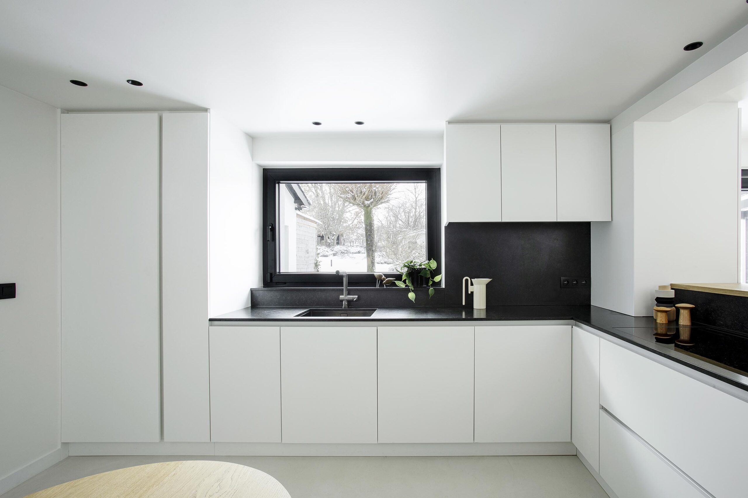 Cuisine contemporaine ouverte dans une maison ancienne rénovée, avec volumes décloisonnés, lumière naturelle et aménagement sur mesure dans une ambiance chaleureuse et haut de gamme