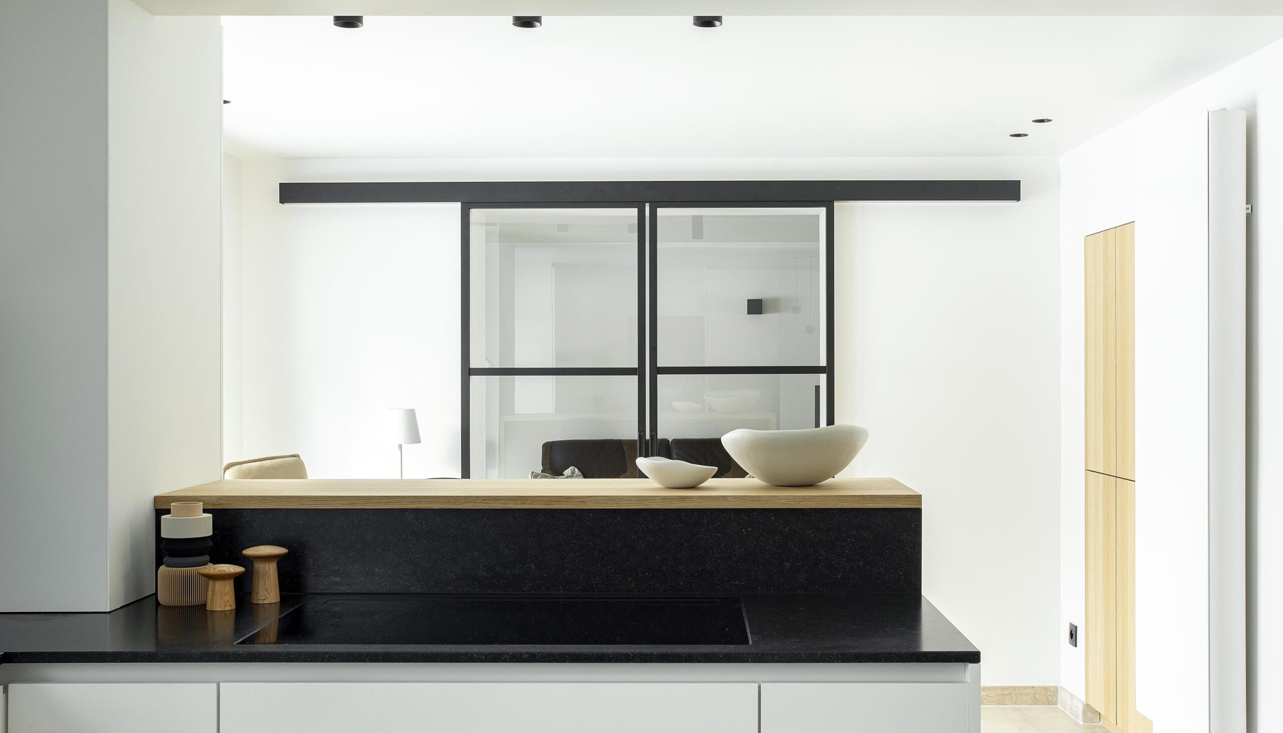 Cuisine contemporaine ouverte dans une maison ancienne rénovée, avec volumes décloisonnés, lumière naturelle et aménagement sur mesure dans une ambiance chaleureuse et haut de gamme