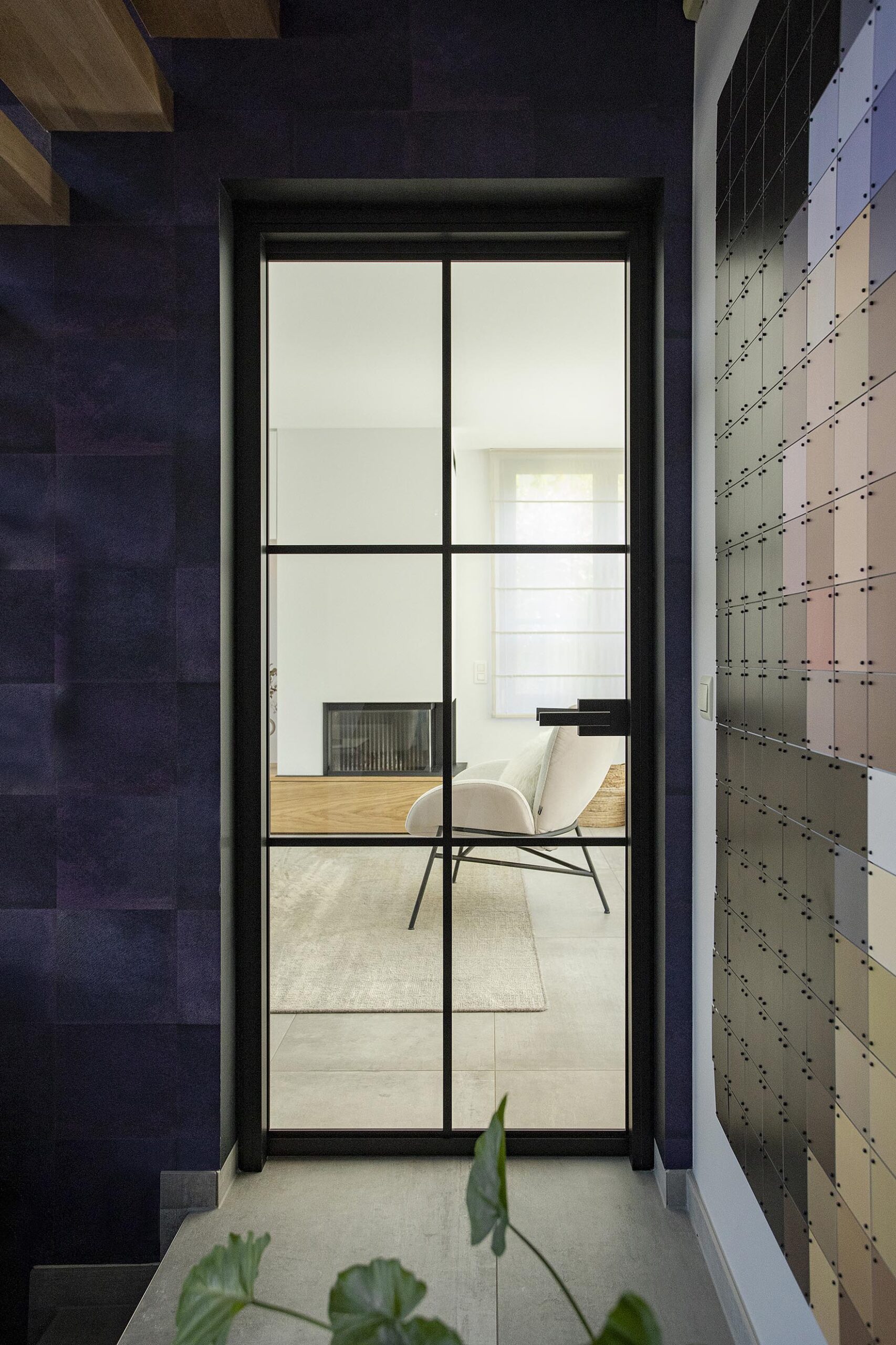 Séjour contemporain avec meuble sur mesure intégrant le foyer et la télévision, chêne clair et accents noirs, dans une ambiance chaleureuse et raffinée