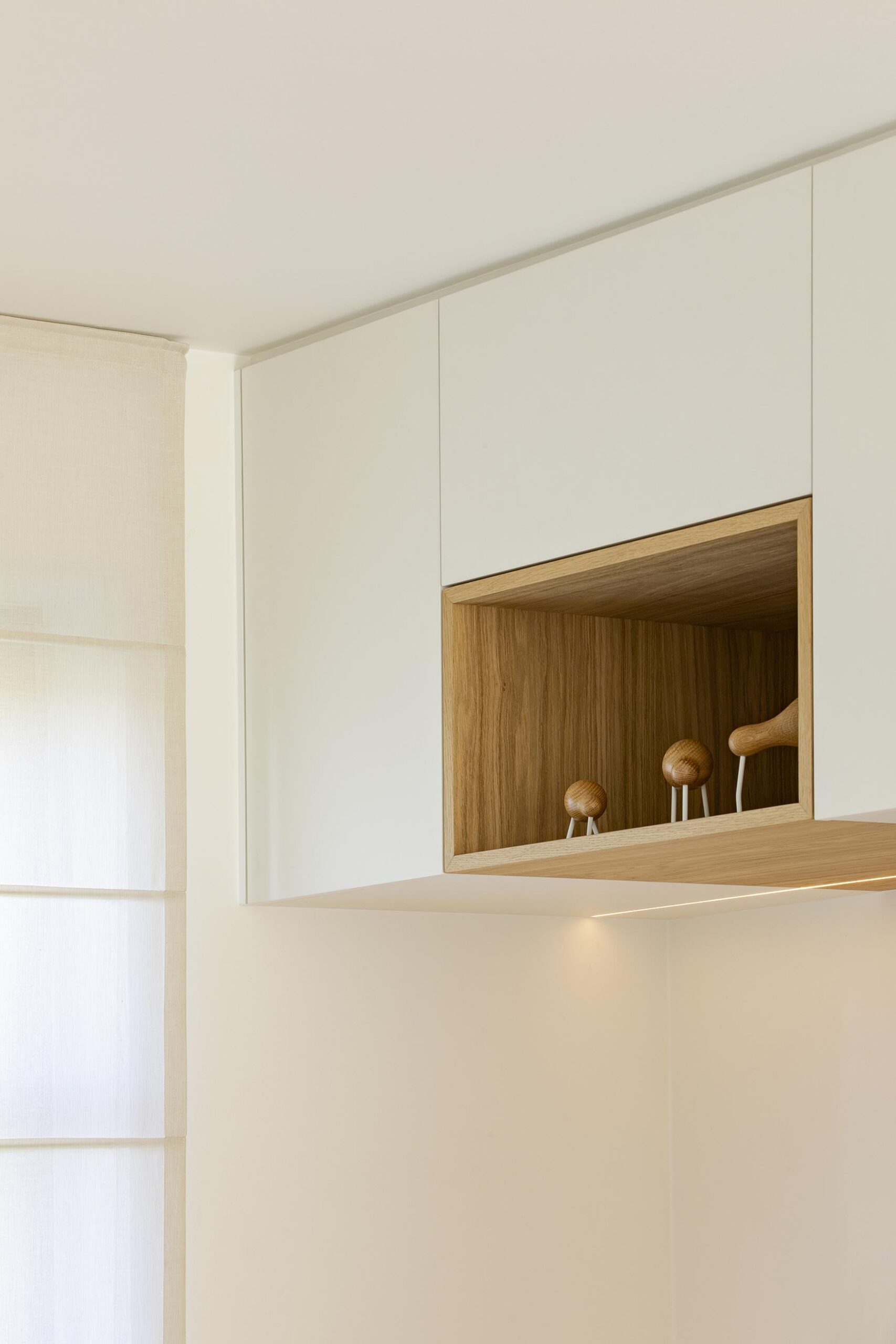 Séjour contemporain avec meuble sur mesure intégrant le foyer et la télévision, chêne clair et accents noirs, dans une ambiance chaleureuse et raffinée