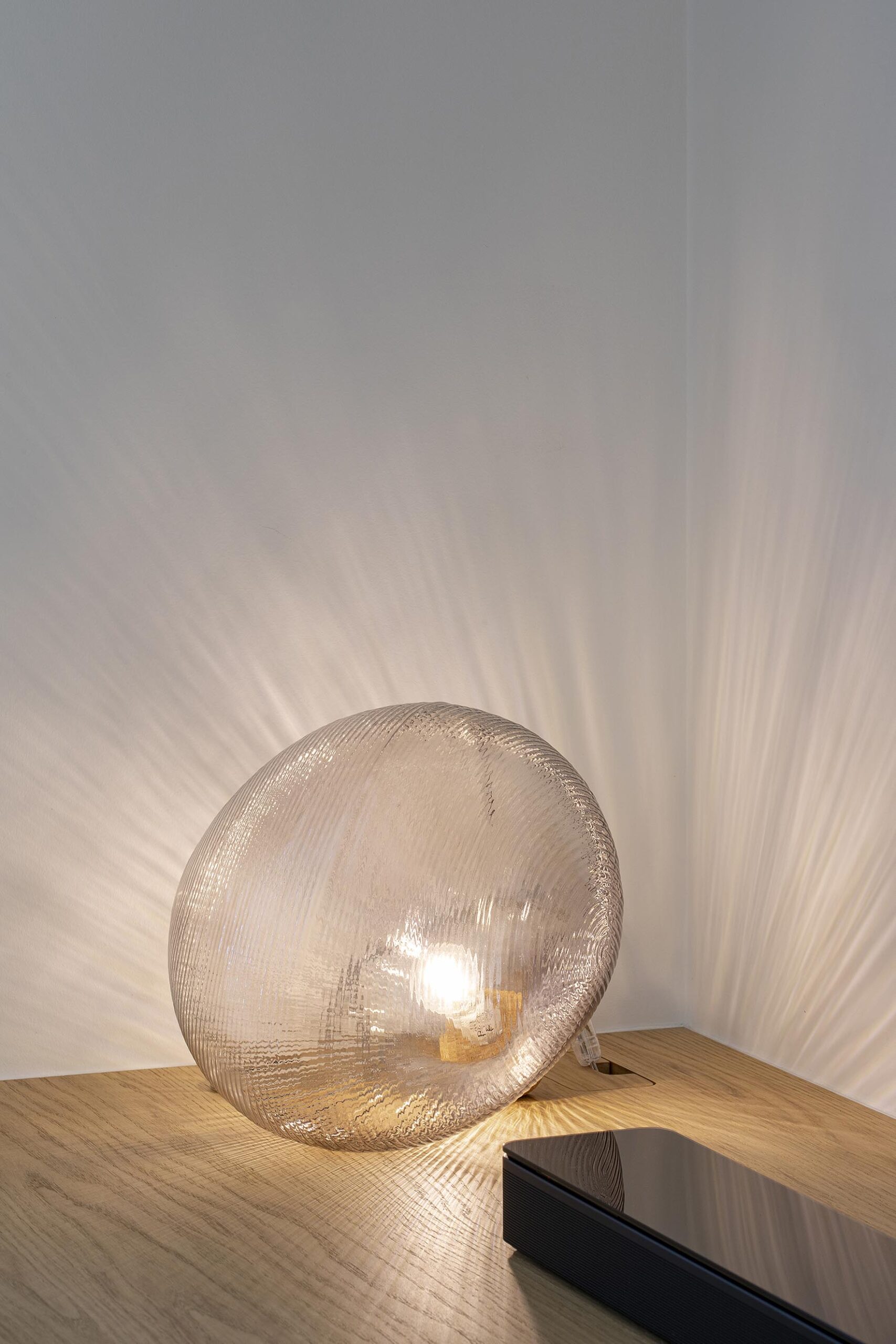 Séjour contemporain avec meuble sur mesure intégrant le foyer et la télévision, chêne clair et accents noirs, dans une ambiance chaleureuse et raffinée