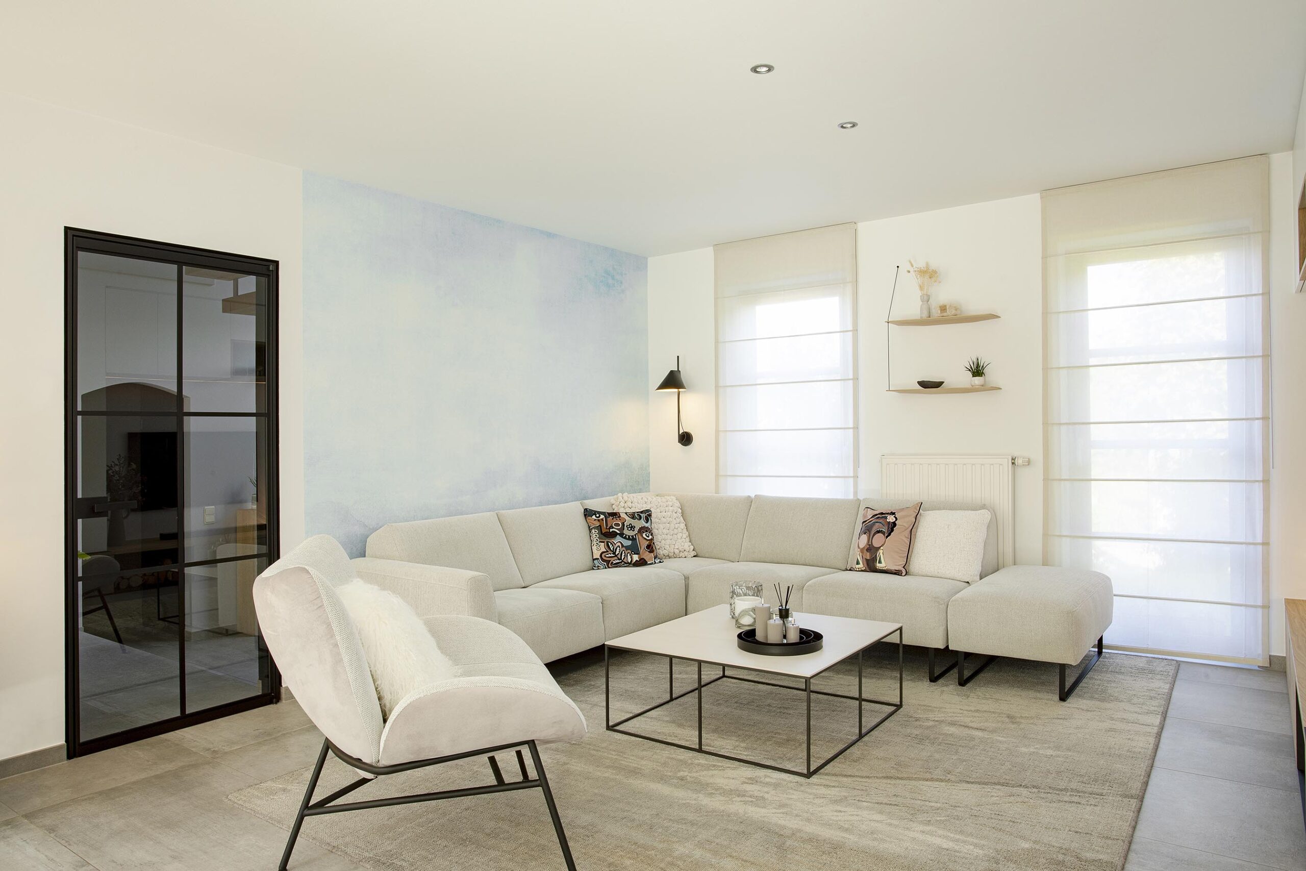Séjour contemporain avec meuble sur mesure intégrant le foyer et la télévision, chêne clair et accents noirs, dans une ambiance chaleureuse et raffinée