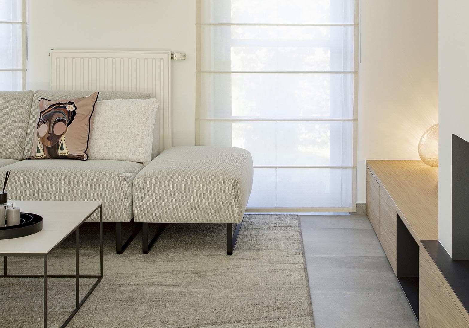Séjour contemporain avec meuble sur mesure intégrant le foyer et la télévision, chêne clair et accents noirs, dans une ambiance chaleureuse et raffinée