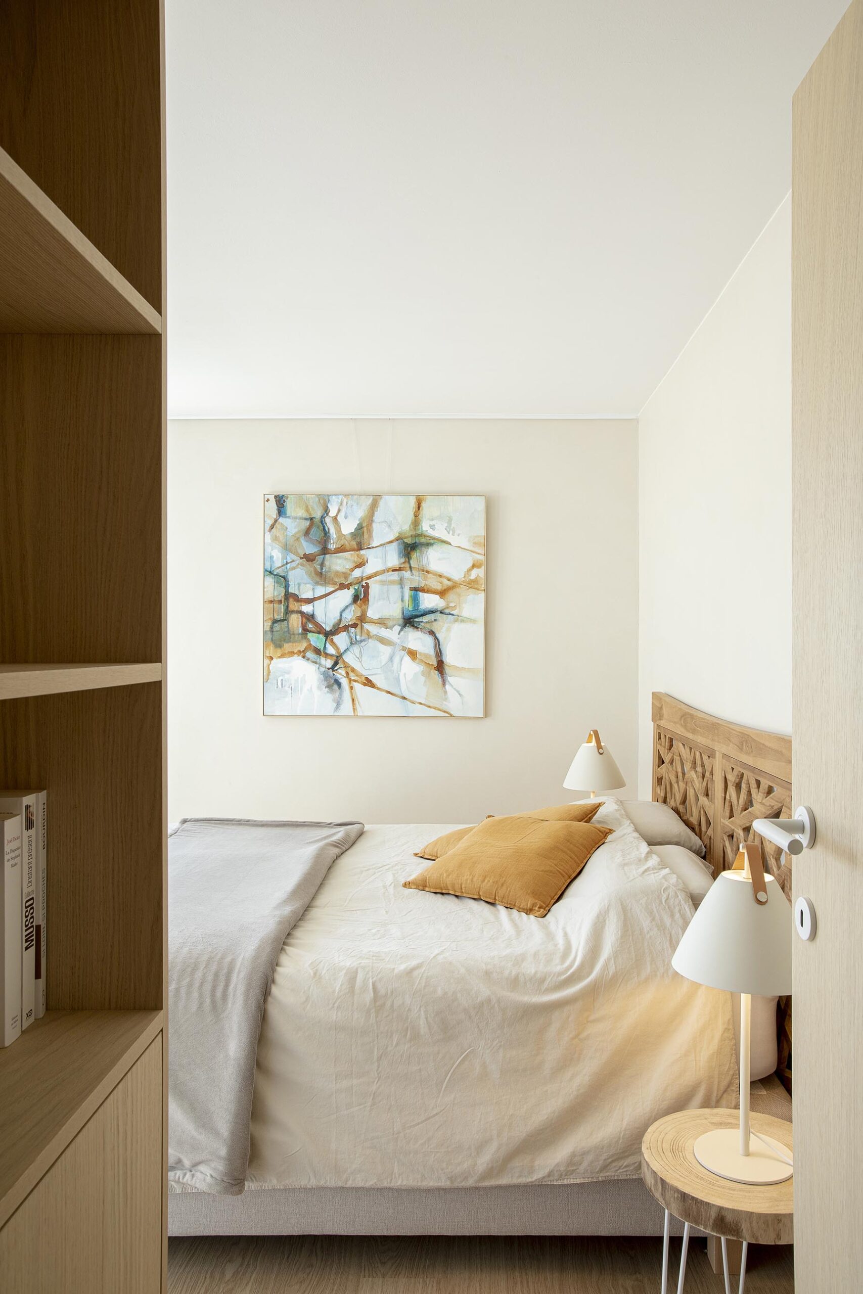 Chambre parentale contemporaine aux tons doux, avec murs à texture minérale, mobilier sur mesure en chêne clair et laque blanche, dans une atmosphère chaleureuse et apaisante