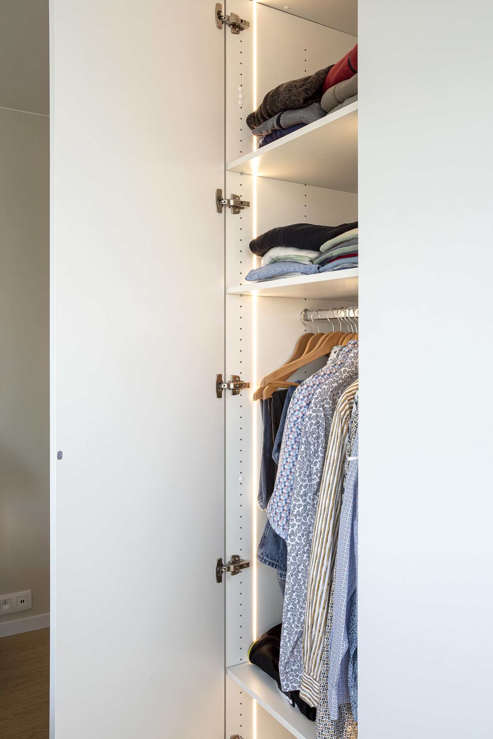 Chambre parentale contemporaine aux tons doux, avec murs à texture minérale, mobilier sur mesure en chêne clair et laque blanche, dans une atmosphère chaleureuse et apaisante