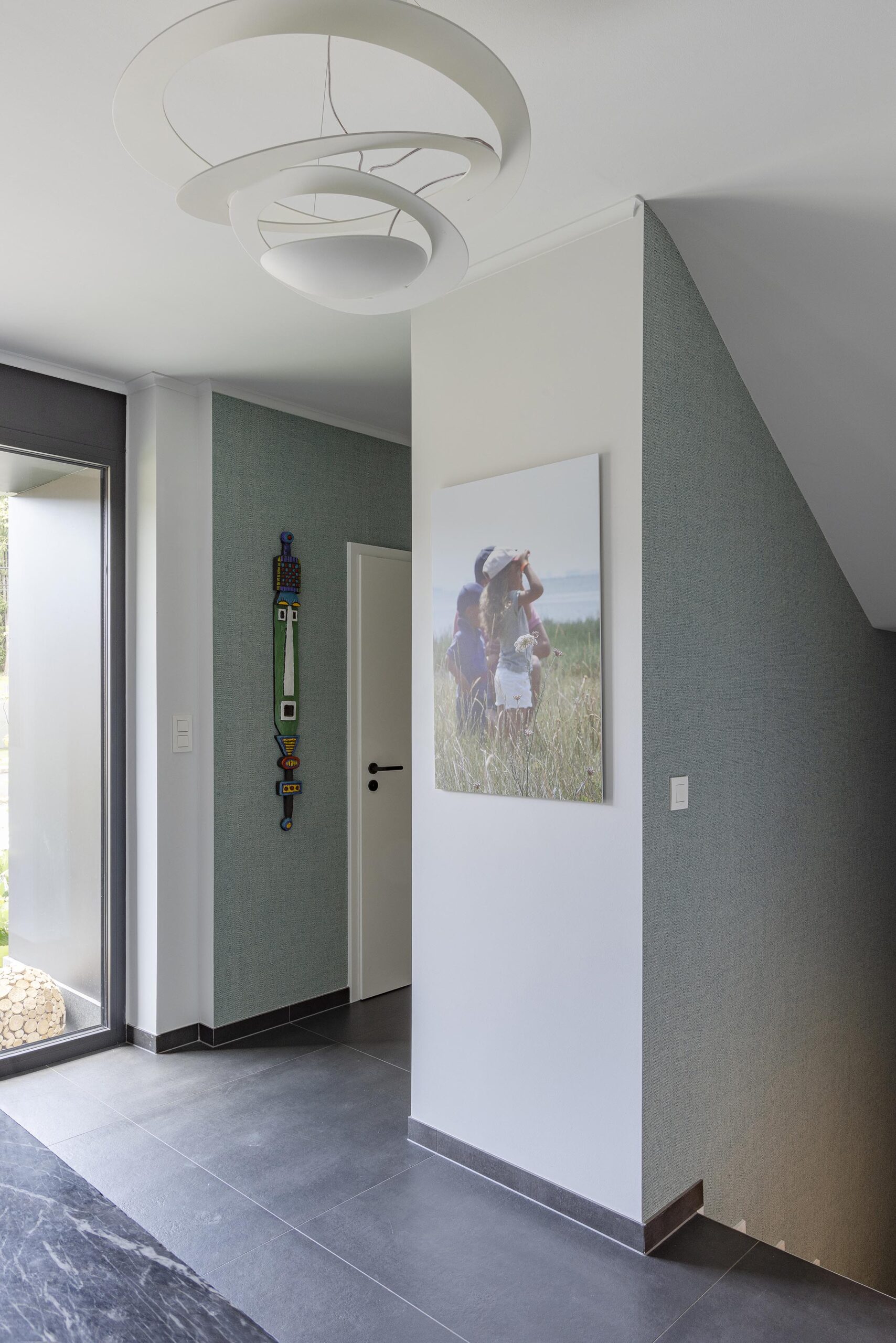 Hall d’entrée contemporain avec papier peint texturé, couleurs enveloppantes et mobilier sur mesure, dans une ambiance élégante, chaleureuse et haut de gamme