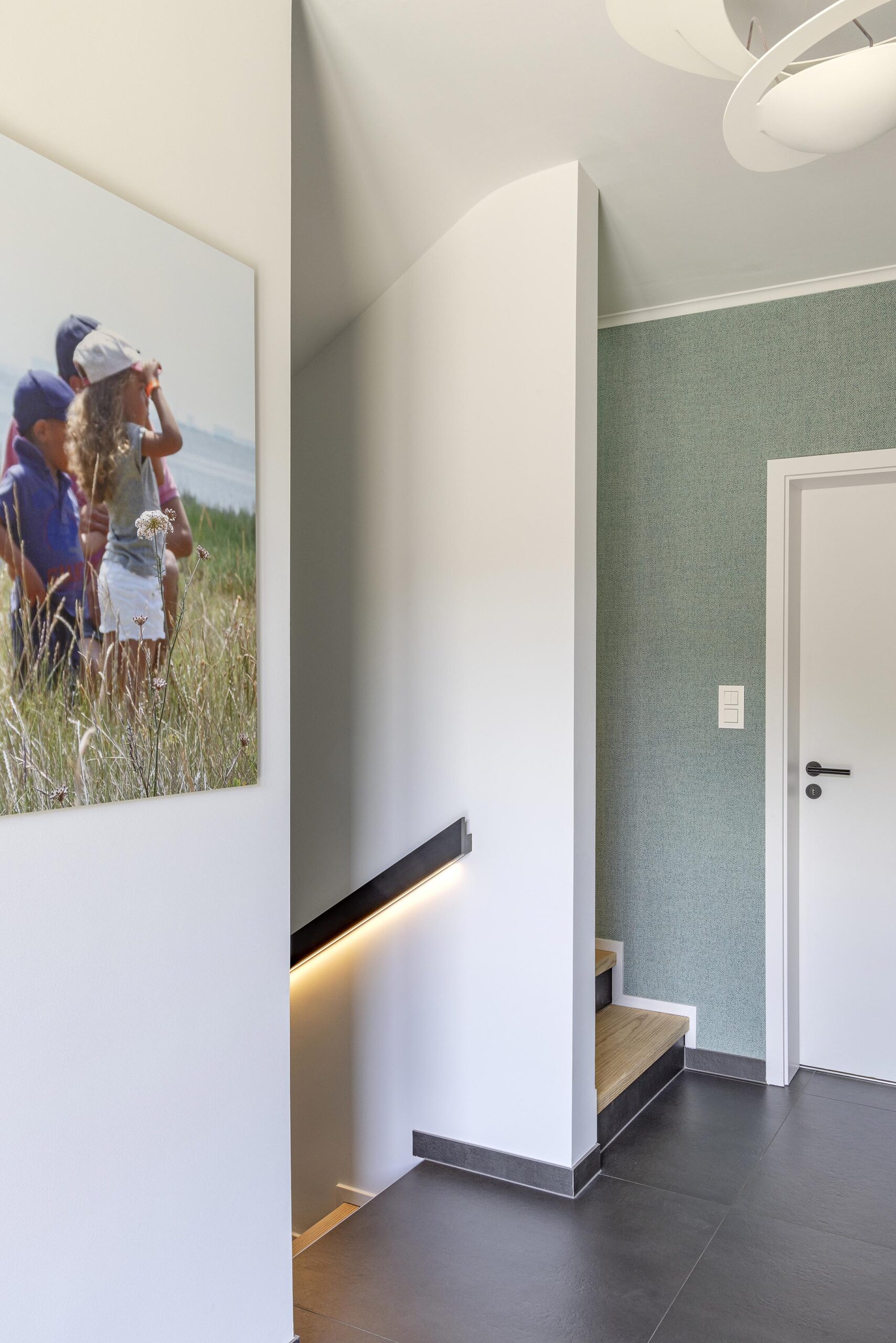 Hall d’entrée contemporain avec papier peint texturé, couleurs enveloppantes et mobilier sur mesure, dans une ambiance élégante, chaleureuse et haut de gamme