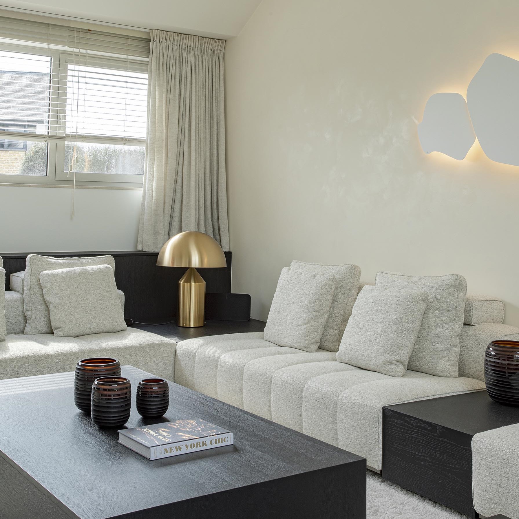 salon contemporain beige, touches de noir et lampe dorée
