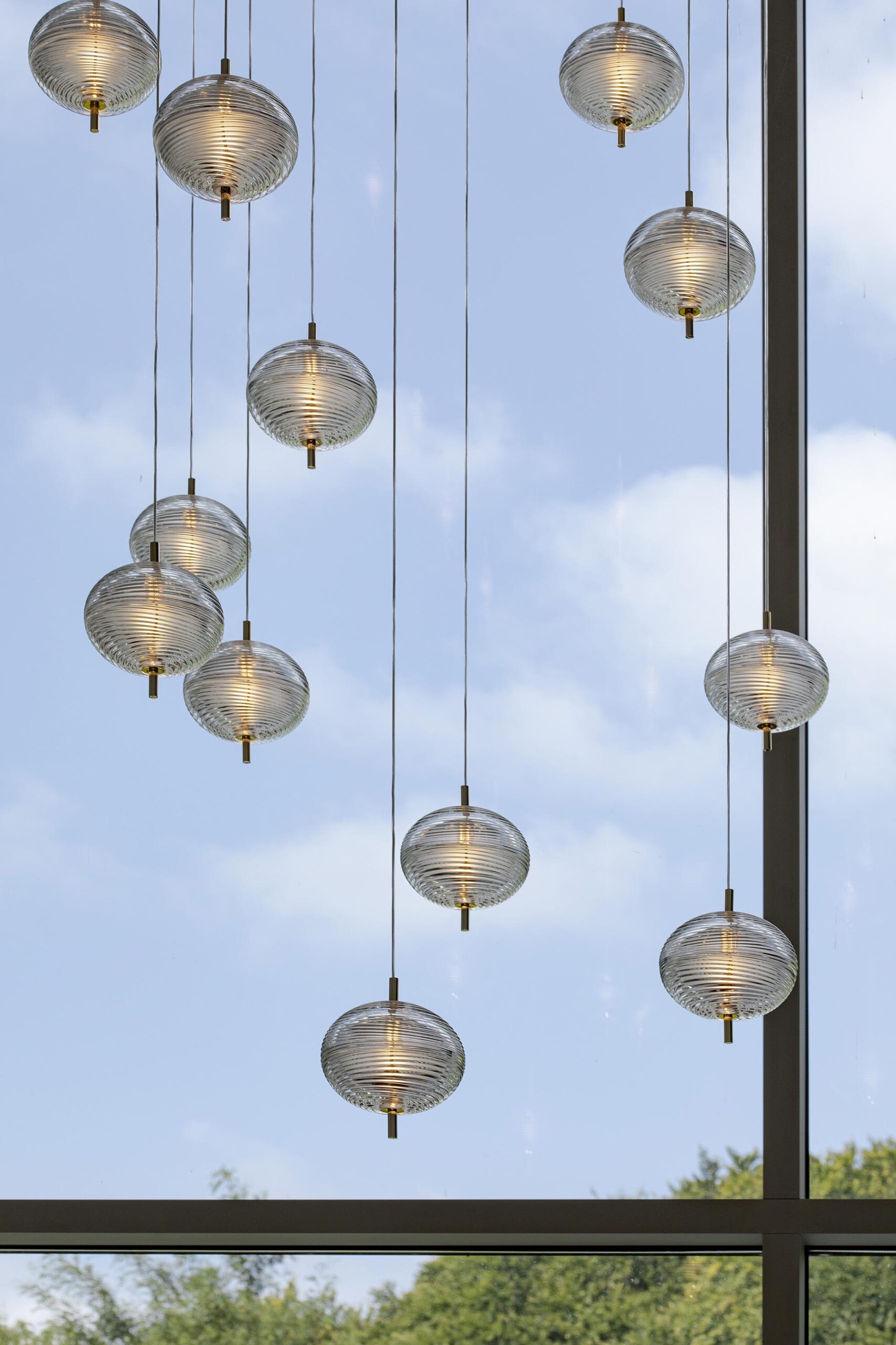 Salon contemporain haut de gamme avec grande baie vitrée, suspension sculpturale en verre soufflé
