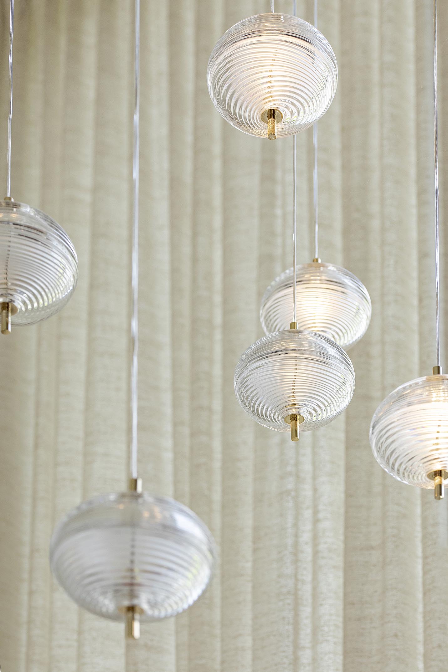 Suspensions boules verre fond rideau beige