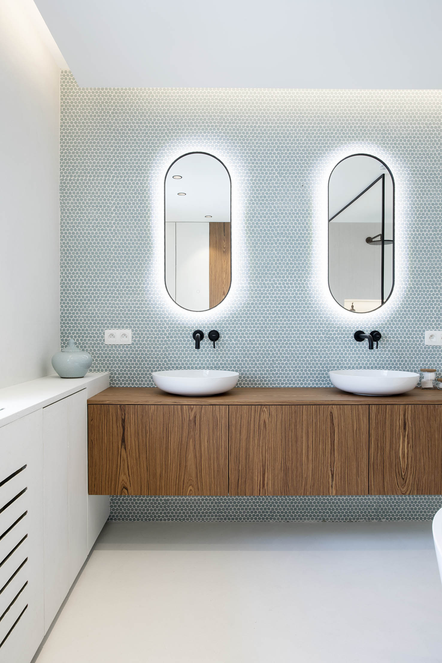 Salle de bains contemporaine avec meuble double vasque en bois, mosaïque bleu-vert et miroirs arrondis rétroéclairés, projet d’architecture d’intérieur à Arlon