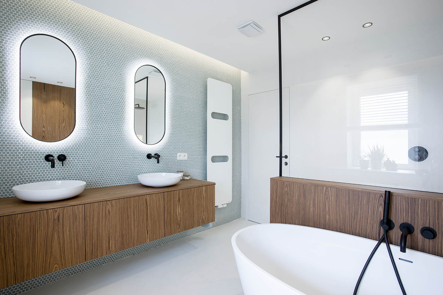 Salle de bains contemporaine avec meuble double vasque en bois, mosaïque bleu-vert et miroirs arrondis rétroéclairés, projet d’architecture d’intérieur à Arlon