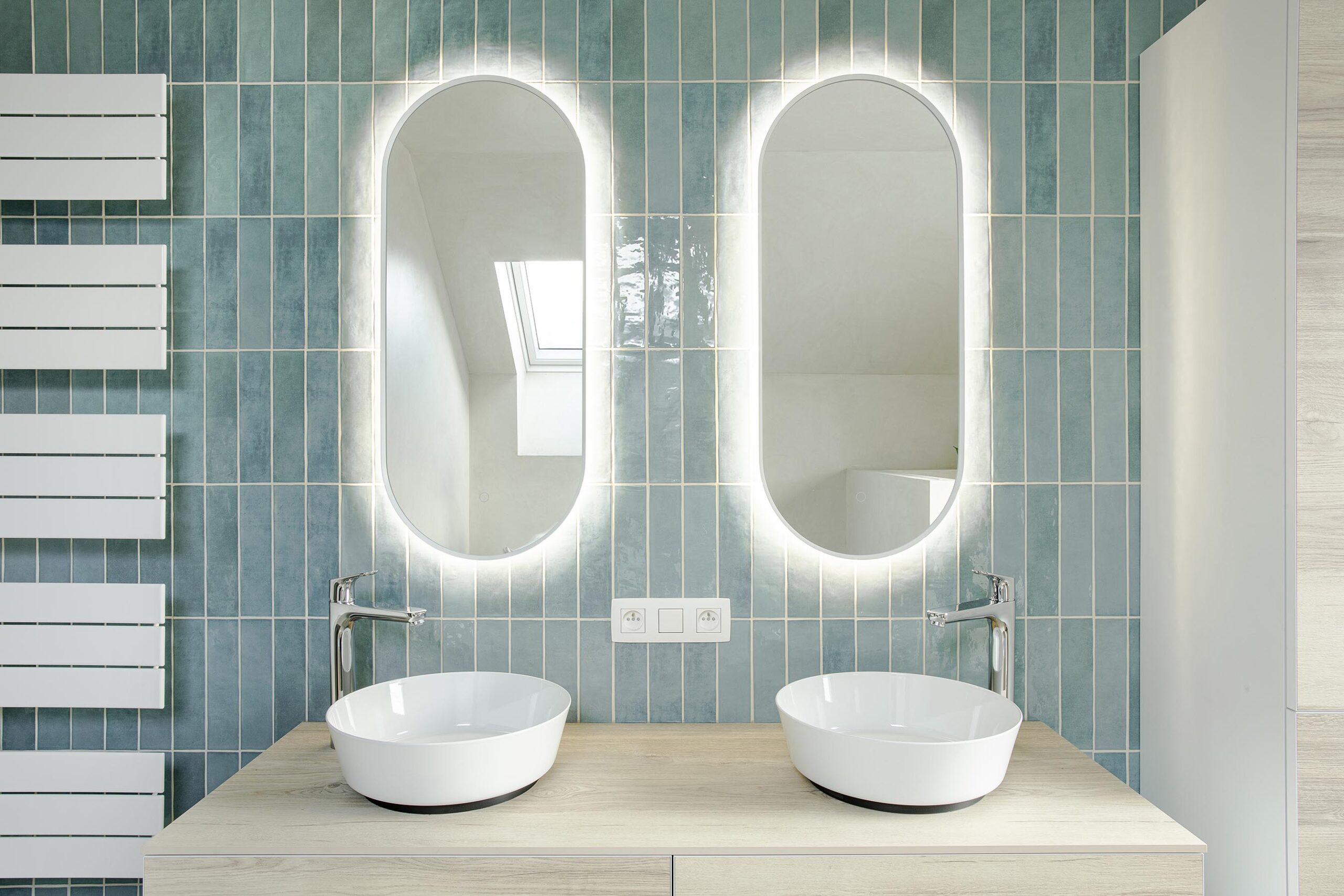 Salle de bains des enfants avec baignoire centrale, structure sur mesure en U et marche intégrée, dans une composition contemporaine, intime et élégante