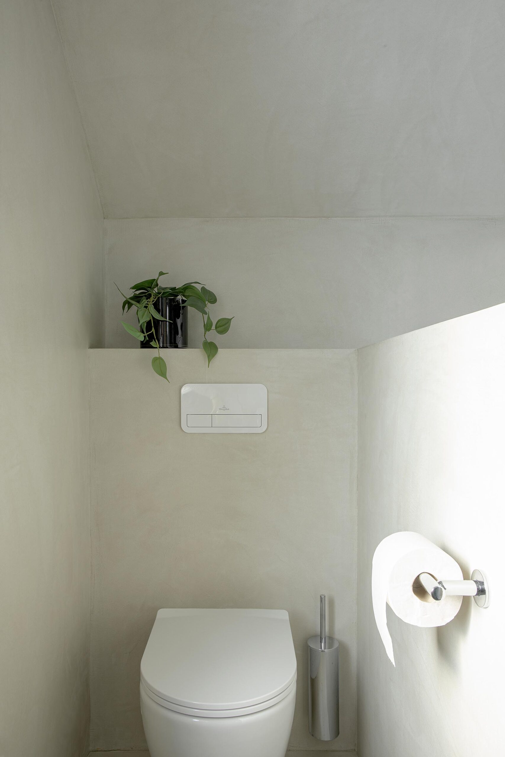 Salle de bains des enfants avec baignoire centrale, structure sur mesure en U et marche intégrée, dans une composition contemporaine, intime et élégante