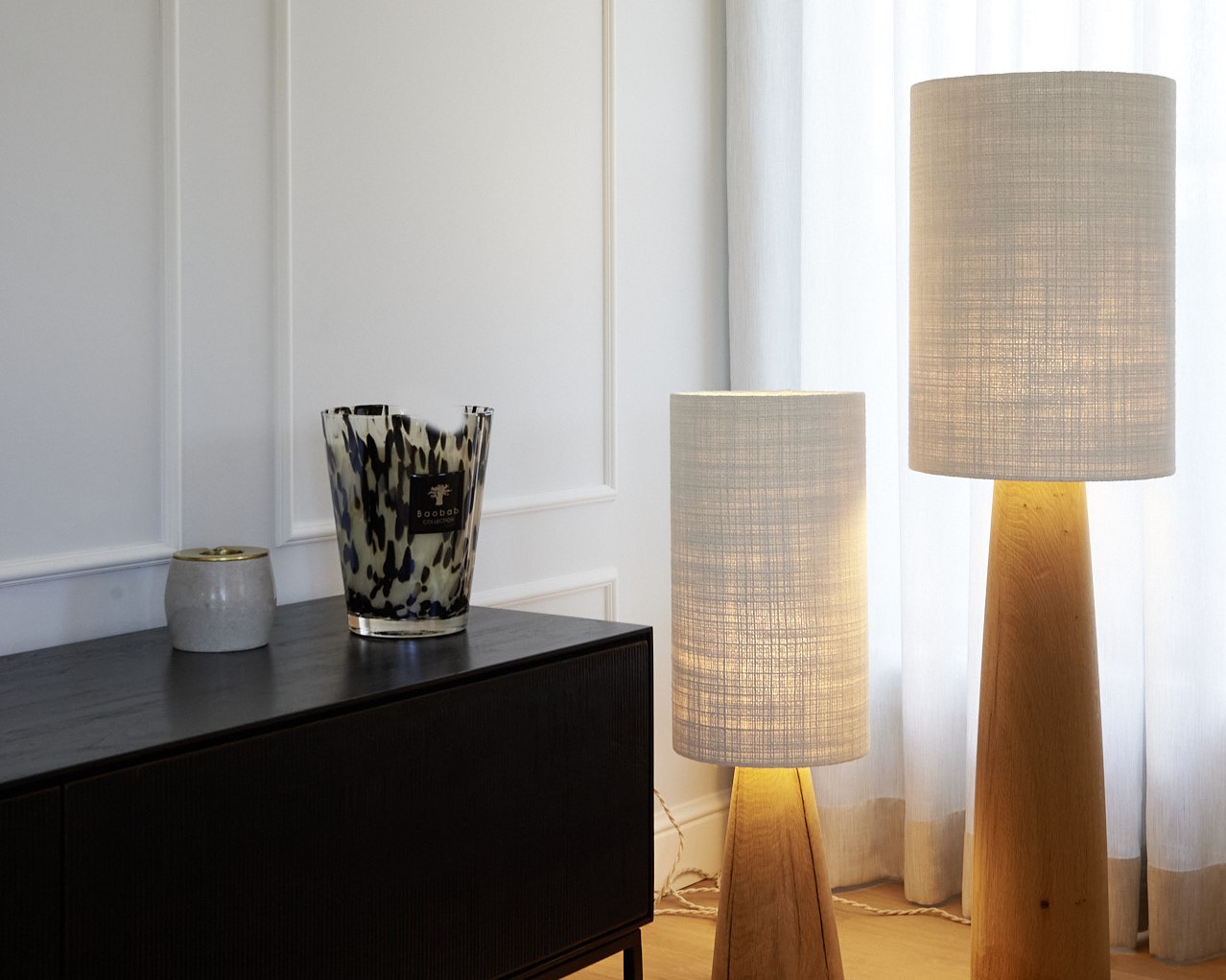 meuble noir mur moulures, 2 lampes sue pied design contemporain