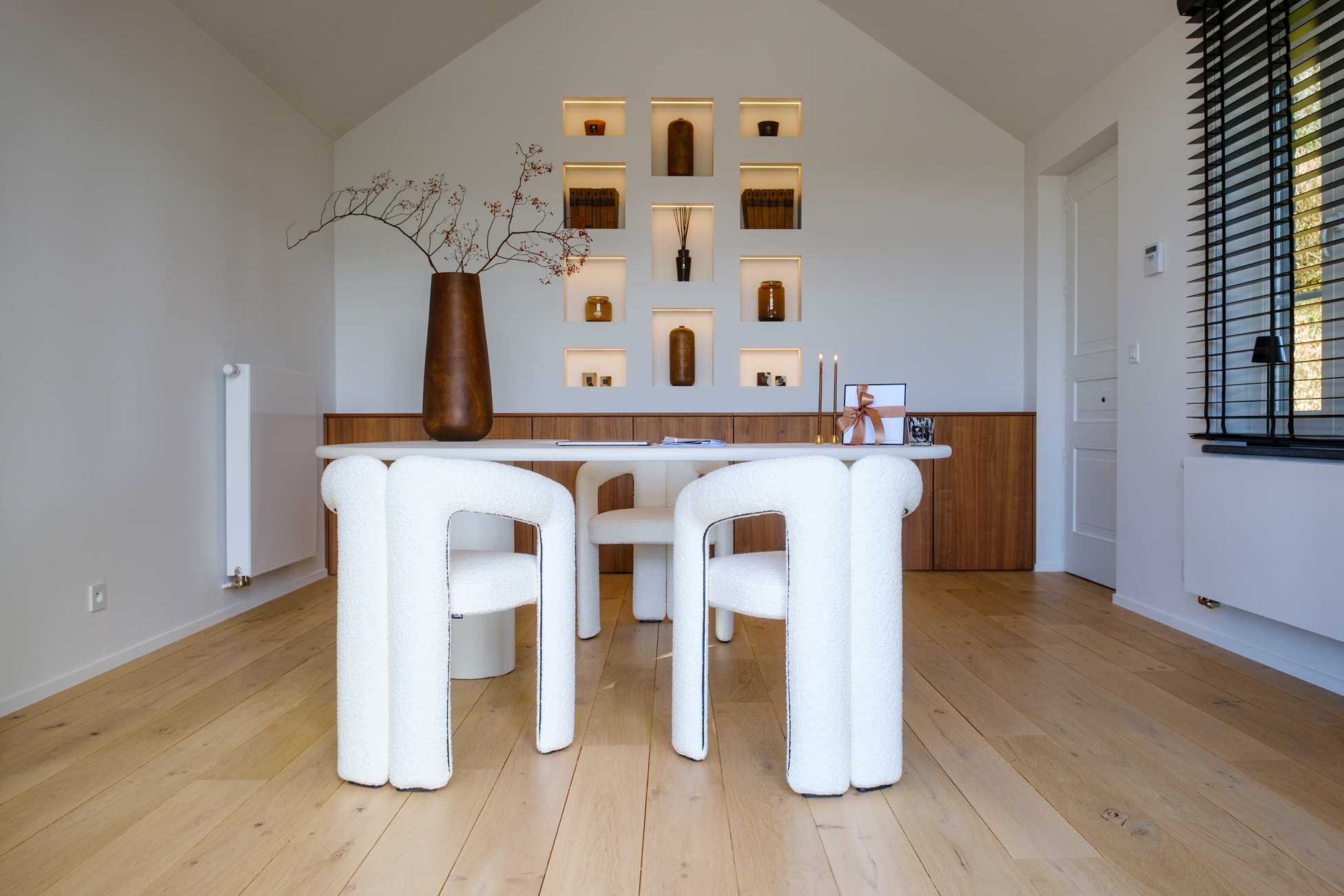 Bureau contemporain avec bureau sur mesure aux lignes organiques, mobilier en noyer et niches murales éclairées