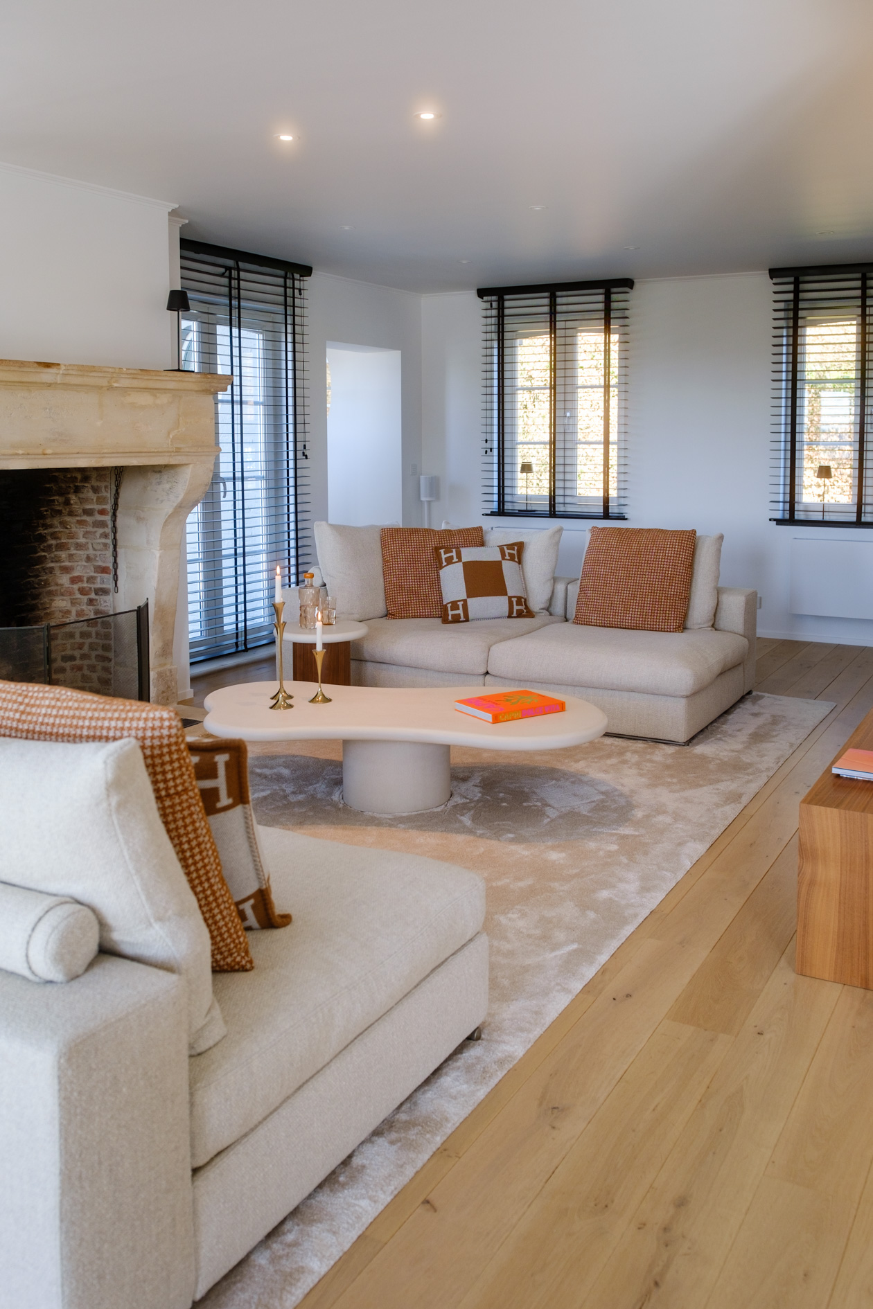 Salle à manger contemporaine avec mobilier sur mesure en noyer, table sculpturale et verrière ouvrant sur la cuisine.