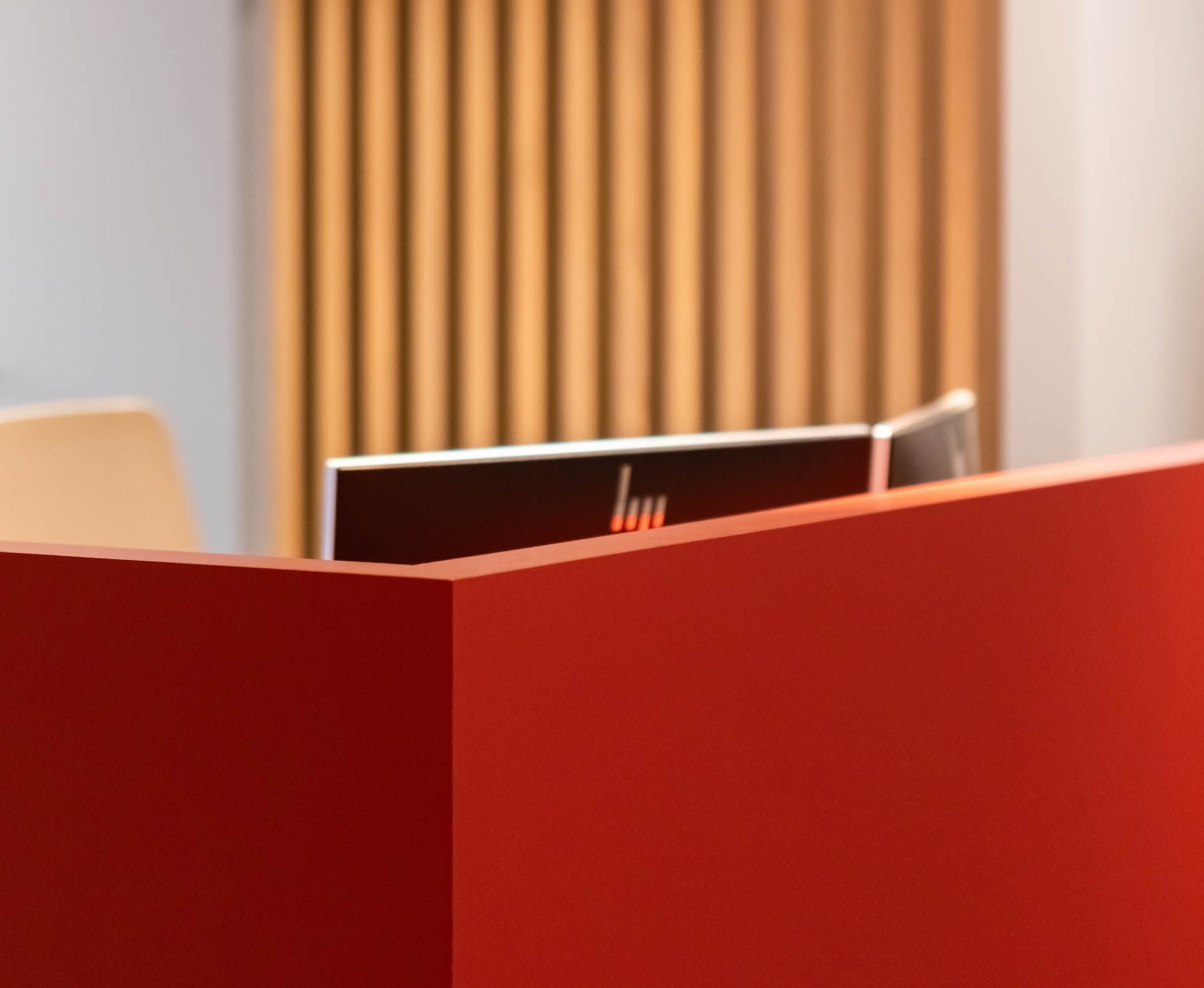 Aménagement intérieur contemporain d’une étude notariale à Namur, avec mobilier en noyer, lignes courbes et accents rouge carmin dans une ambiance professionnelle haut de gamme
