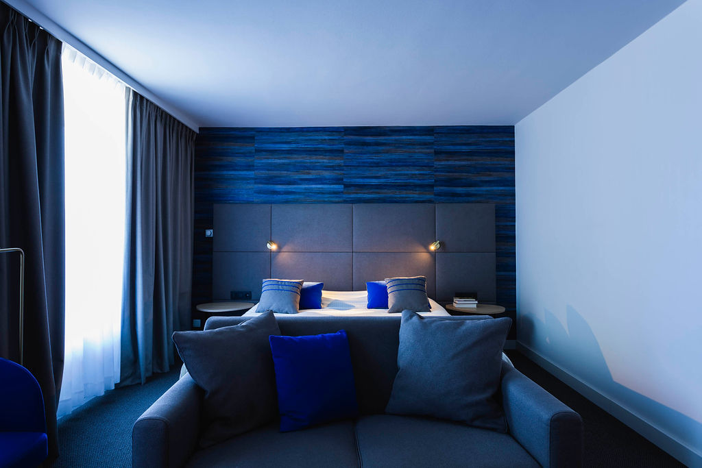 Chambre contemporaine de l’Hôtel Les 3 Clés à Gembloux, avec mobilier sur mesure, textiles raffinés, papier peint structuré et détails en laiton dans une ambiance haut de gamme et apaisante