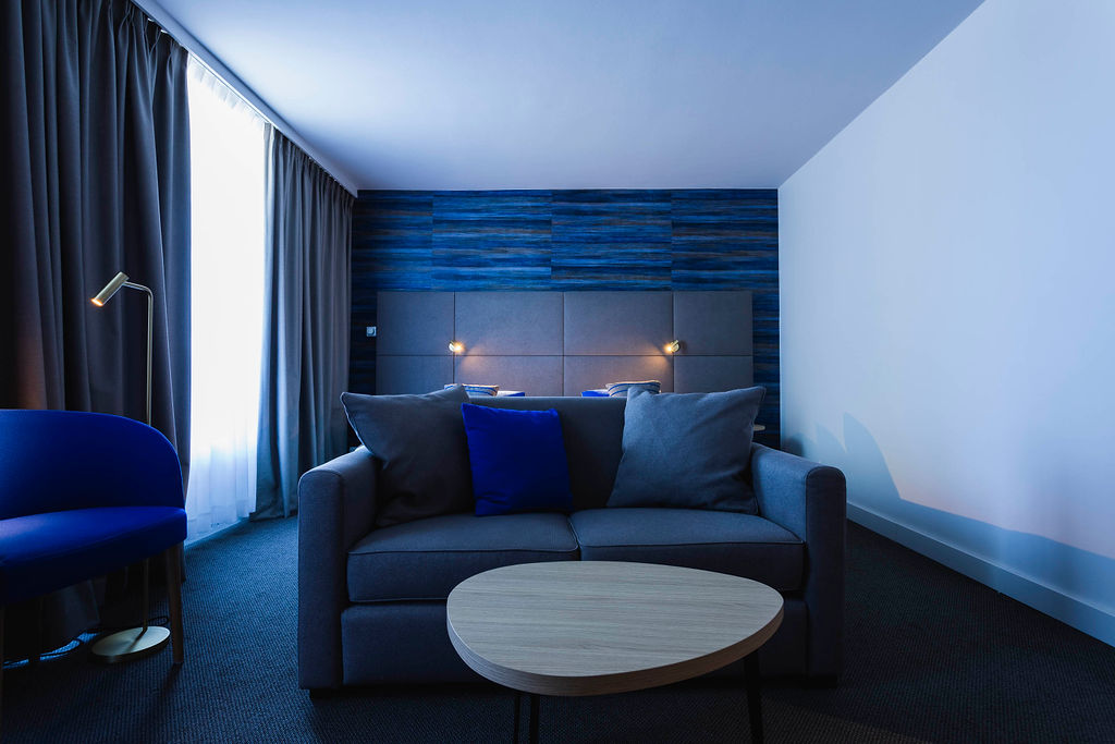 Chambre contemporaine de l’Hôtel Les 3 Clés à Gembloux, avec mobilier sur mesure, textiles raffinés, papier peint structuré et détails en laiton dans une ambiance haut de gamme et apaisante