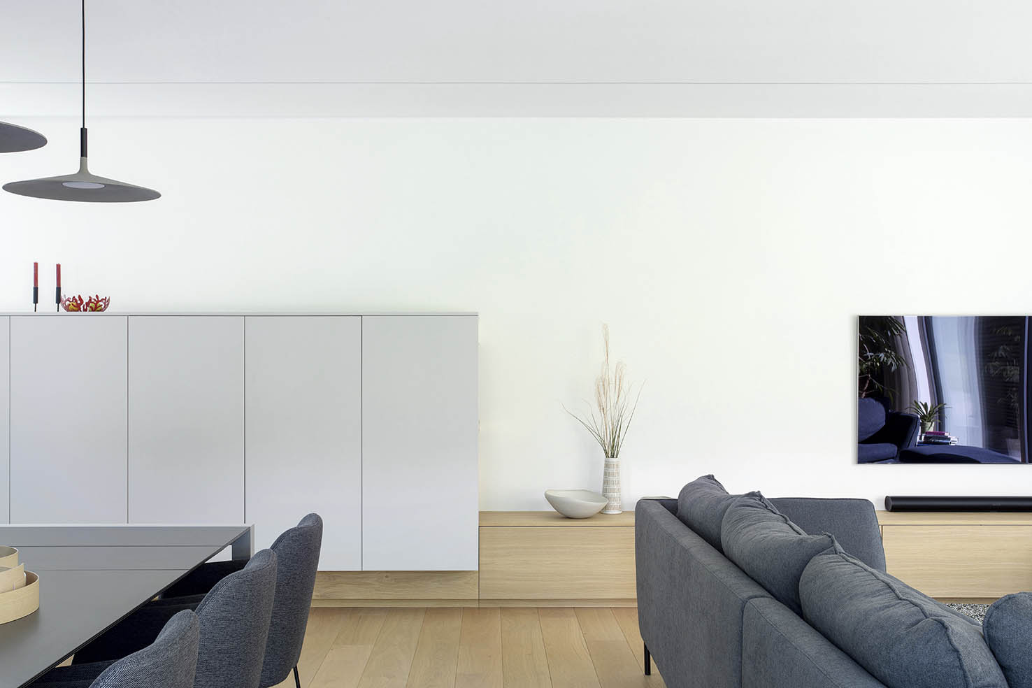 séjour mobilier sur mesure en bois clair, banquette intégrée et meuble TV, projet d’architecture d’intérieur à Arlon.