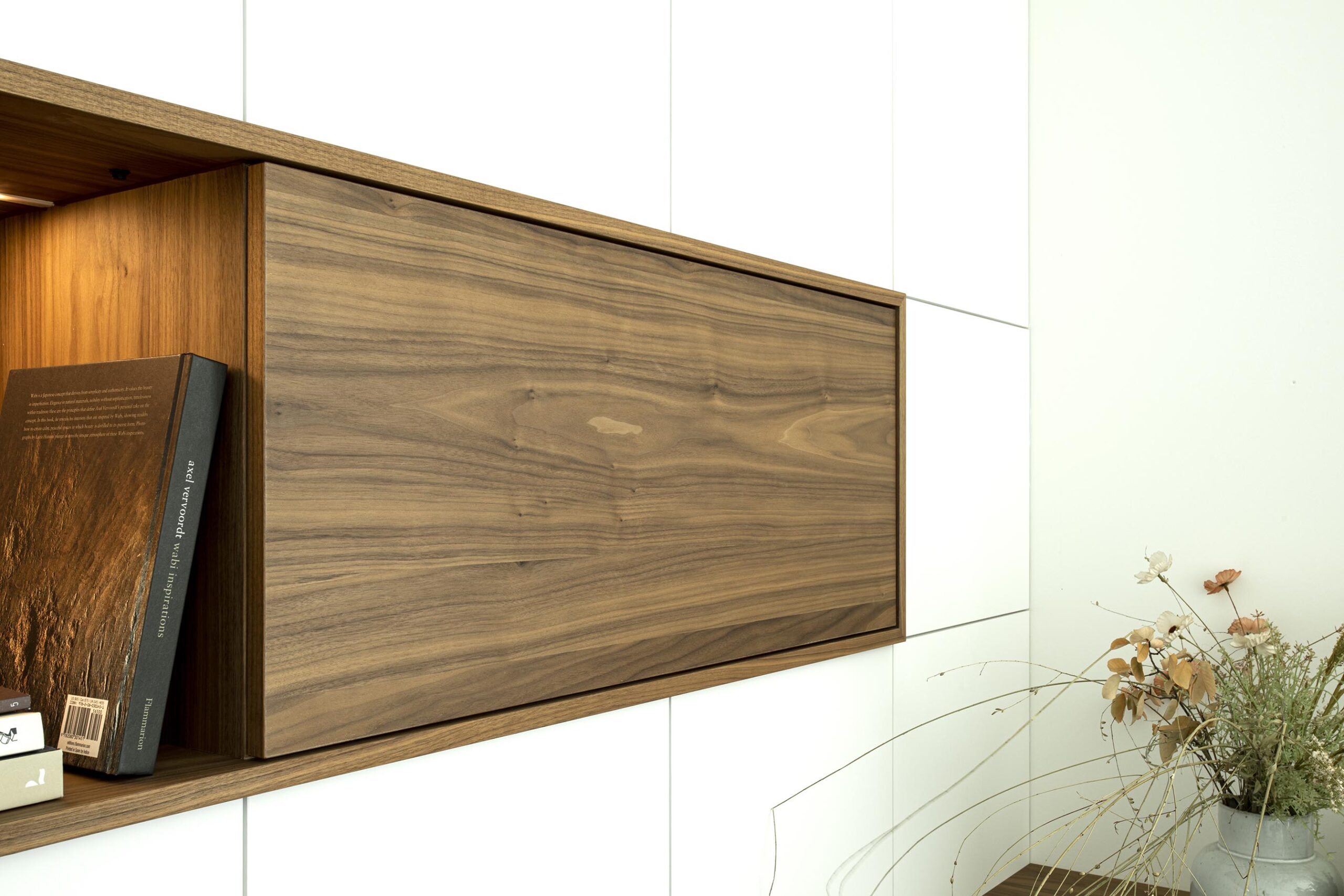 Salon contemporain lumineux avec mobilier sur mesure blanc et bois, niche intégrée éclairée et grandes baies vitrées, projet d’architecture d’intérieur à Arlon