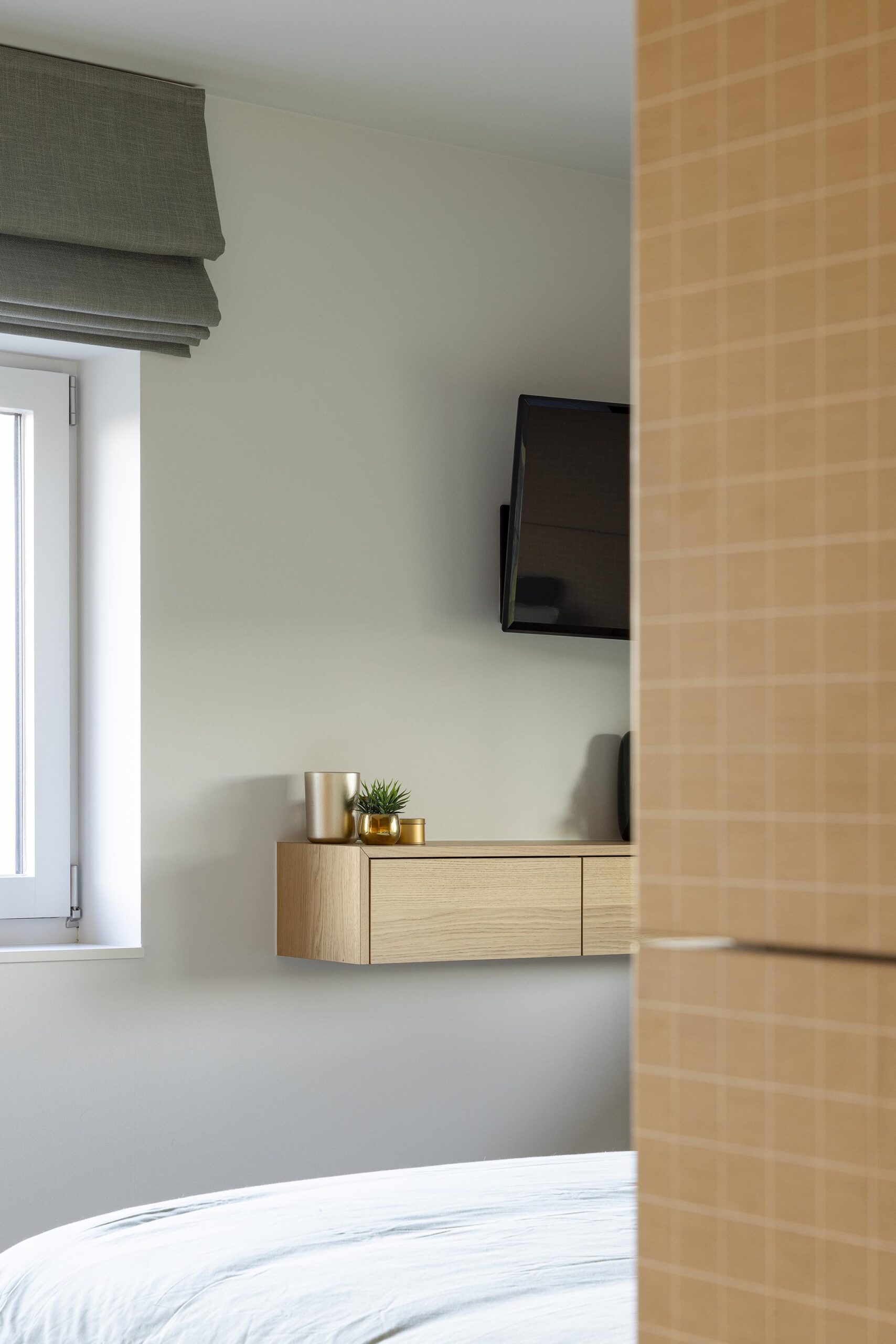 Chambre parentale contemporaine à Stavelot, avec parquet chaleureux, mobilier sur mesure, rangements intégrés et finitions raffinées dans une ambiance élégante et intimiste