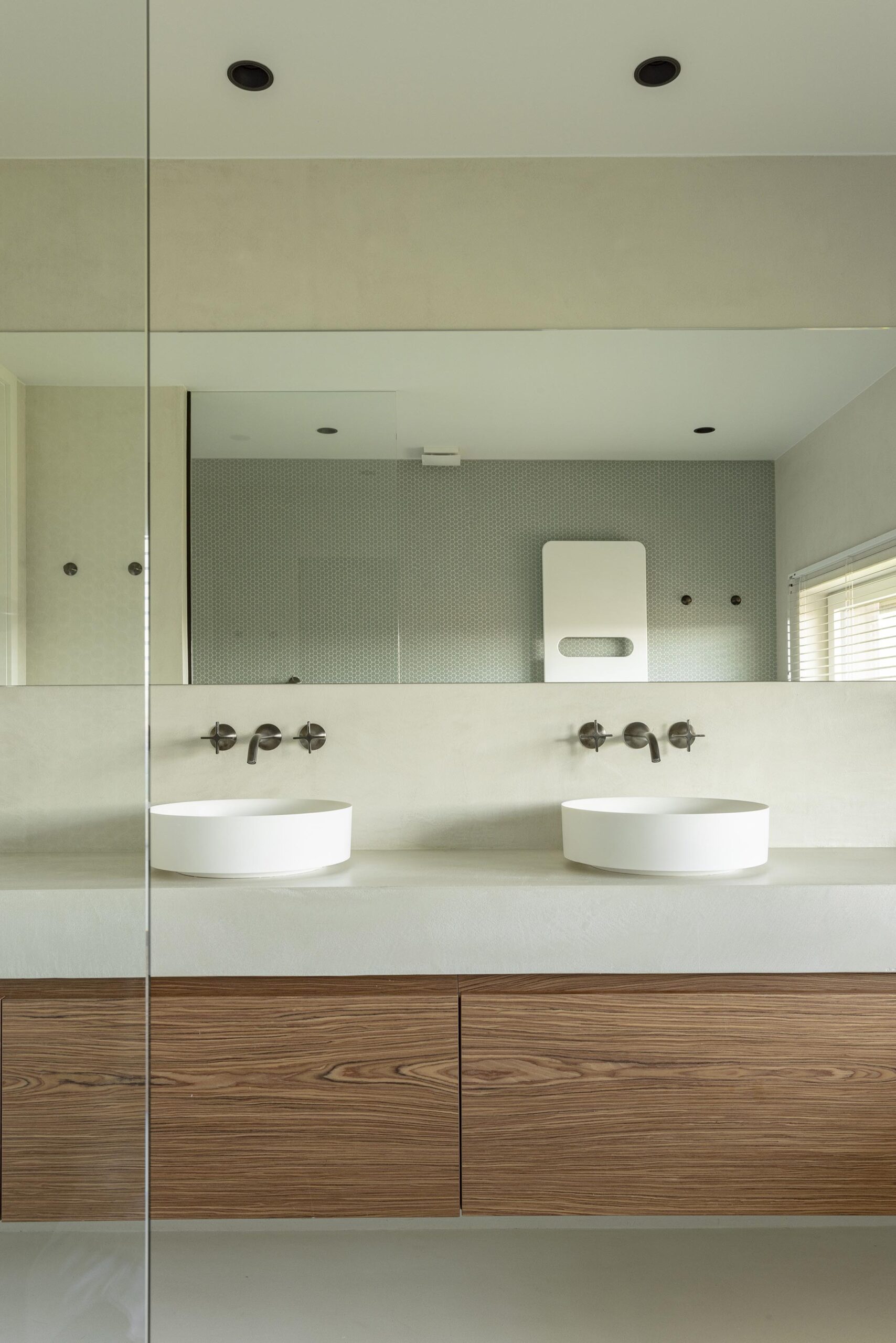 Meuble double vasque sur mesure en palissandre, avec grand miroir mural et veinage naturel contrasté, pour une salle de bains élégante et haut de gamme